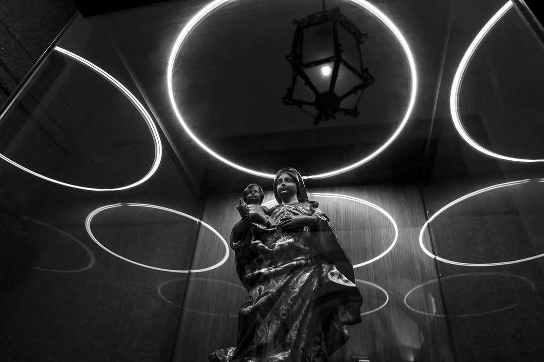 Estátua da Virgem com o Menino iluminada por círculos de néon
